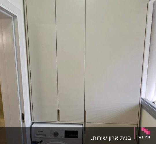 ארון עץ גבוה ליד מכונת כביסה